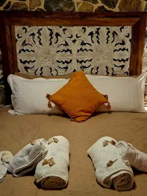 a bed with towels and pillows on it at STONE of KAMARIZA in Áyios Konstandínos