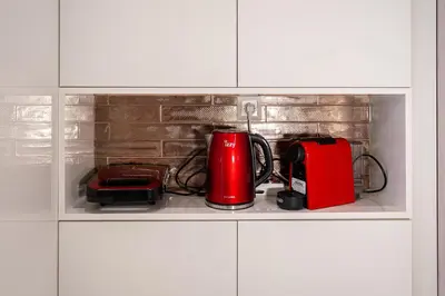 a red coffee maker and a toaster on a counter at Gkizi View in Athens