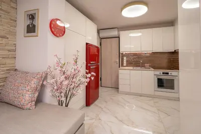 a kitchen with a red refrigerator and white cabinets at Gkizi View in Athens