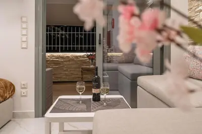 a living room with two glasses of wine on a table at Gkizi View in Athens