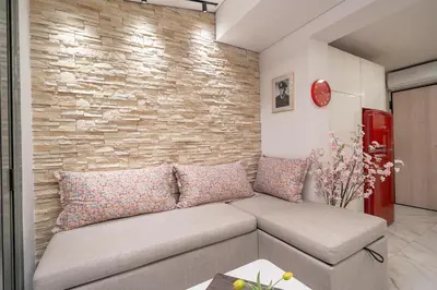 a living room with a couch and a brick wall at Gkizi View in Athens