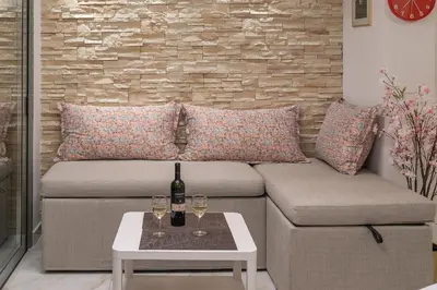 a living room with a couch and two glasses of wine at Gkizi View in Athens