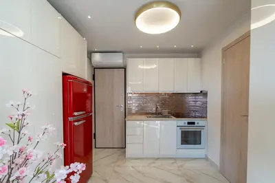 a kitchen with white cabinets and a red refrigerator at Gkizi View in Athens