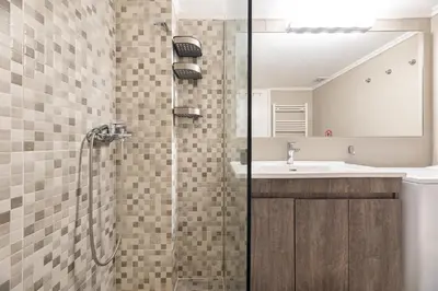 a bathroom with a shower with a sink and a mirror at A2 3-Bedrms Ap 112sm 850m Metro Evangelismos 150m EKPA Univ Campus 100m Bus Stop to Acropolis in Athens