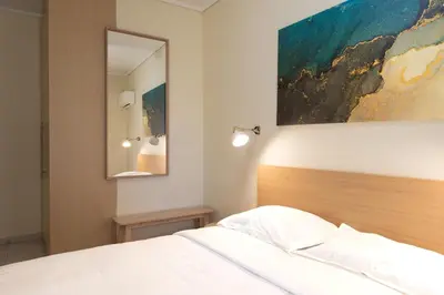 a bedroom with a bed and a painting on the wall at A2 3-Bedrms Ap 112sm 850m Metro Evangelismos 150m EKPA Univ Campus 100m Bus Stop to Acropolis in Athens