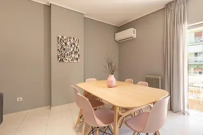 a dining room with a wooden table and pink chairs at A2 3-Bedrms Ap 112sm 850m Metro Evangelismos 150m EKPA Univ Campus 100m Bus Stop to Acropolis in Athens