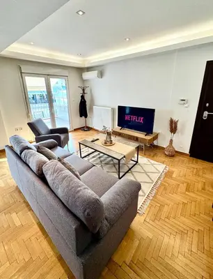 a living room with a couch and a tv at Bright Apartment Syntagma Square in Athens