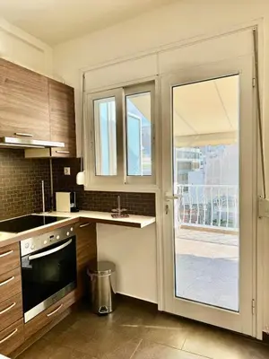 a kitchen with a large glass door leading to a patio at Bright Apartment Syntagma Square in Athens