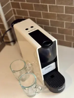 a cell phone holder next to glasses on a counter at Bright Apartment Syntagma Square in Athens