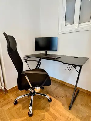 a black desk with a computer monitor and a chair at Bright Apartment Syntagma Square in Athens
