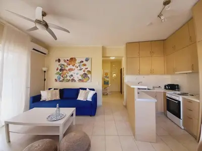a living room with a blue couch and a kitchen at C4 2-Rooms apt 3rd 850m Metro Evangelismos 150m EKPA Univ Campus 100m Bus Stop to Acropolis in Athens