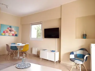 a living room with a table and chairs and a television at C4 2-Rooms apt 3rd 850m Metro Evangelismos 150m EKPA Univ Campus 100m Bus Stop to Acropolis in Athens