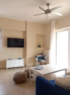 a living room with a couch and a ceiling fan at C4 2-Rooms apt 3rd 850m Metro Evangelismos 150m EKPA Univ Campus 100m Bus Stop to Acropolis in Athens