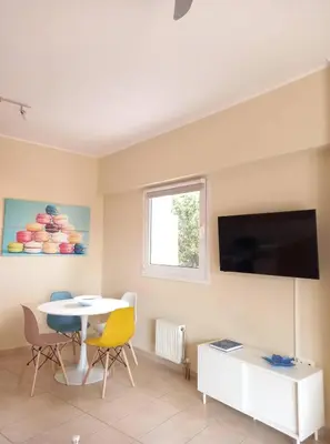 a living room with a table and a tv on a wall at C4 2-Rooms apt 3rd 850m Metro Evangelismos 150m EKPA Univ Campus 100m Bus Stop to Acropolis in Athens