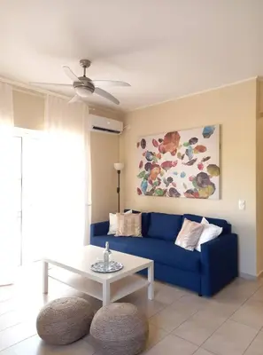 a living room with a blue couch and a table at C4 2-Rooms apt 3rd 850m Metro Evangelismos 150m EKPA Univ Campus 100m Bus Stop to Acropolis in Athens
