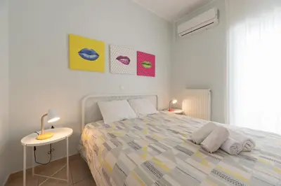 a white bedroom with a bed and a table at C5 3rd floor balcony view 1bdr flat 850m Metro Evangelismos 150m EKPA University Campus 100m Bus Stop to Acropolis in Athens