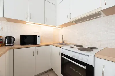 a kitchen with white cabinets and a white stove top oven at C5 3rd floor balcony view 1bdr flat 850m Metro Evangelismos 150m EKPA University Campus 100m Bus Stop to Acropolis in Athens