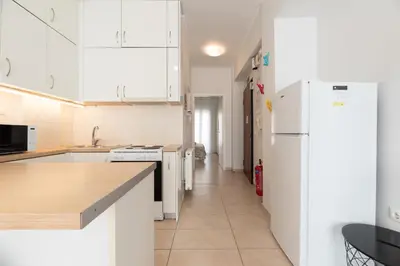 a kitchen with white cabinets and a white refrigerator at C5 3rd floor balcony view 1bdr flat 850m Metro Evangelismos 150m EKPA University Campus 100m Bus Stop to Acropolis in Athens