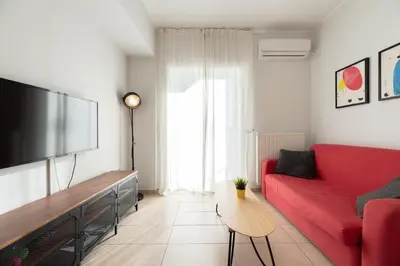 a living room with a red couch and a flat screen tv at C5 3rd floor balcony view 1bdr flat 850m Metro Evangelismos 150m EKPA University Campus 100m Bus Stop to Acropolis in Athens