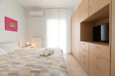 a bedroom with a large bed with a flat screen tv at C5 3rd floor balcony view 1bdr flat 850m Metro Evangelismos 150m EKPA University Campus 100m Bus Stop to Acropolis in Athens