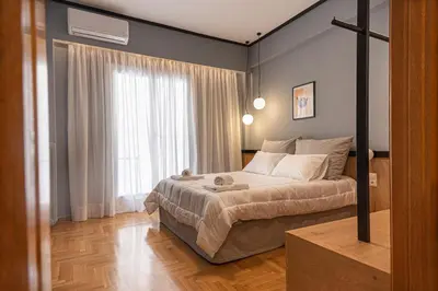 a bedroom with a bed and a large window at Elegant Minimal Apartment in Athens