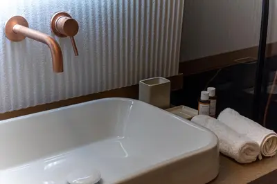 a bathroom with a white sink and a mirror at Elegant Minimal Apartment in Athens