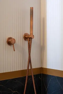 a bathroom with a wooden toilet plunger next to a wall at Elegant Minimal Apartment in Athens
