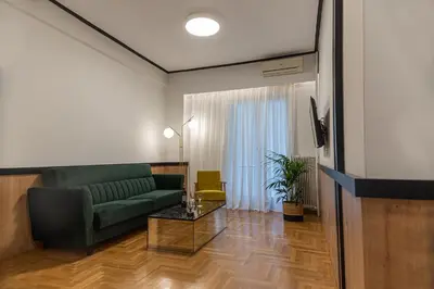 a living room with a green couch and a table at Elegant Minimal Apartment in Athens