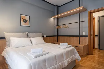 a bedroom with a large bed with two towels on it at Elegant Minimal Apartment in Athens