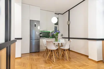 a kitchen with a table and chairs and a refrigerator at Elegant Minimal Apartment in Athens