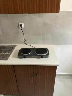a black appliance plugged into an outlet on a kitchen counter at Giorgio in Piraeus