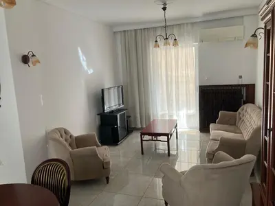 a living room with a couch and chairs and a tv at Giorgio in Piraeus