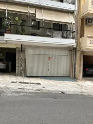 an apartment building with a garage with a parking lot at Giorgio in Piraeus