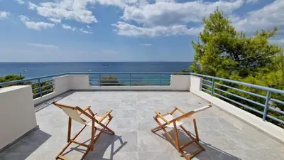 a balcony with two chairs and a view of the ocean at Athenian Riviera Seafront Residence in Saronida
