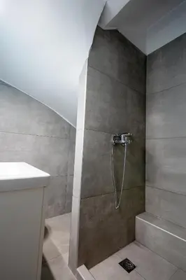 a bathroom with a shower with a shower head at Athenian Riviera Seafront Residence in Saronida