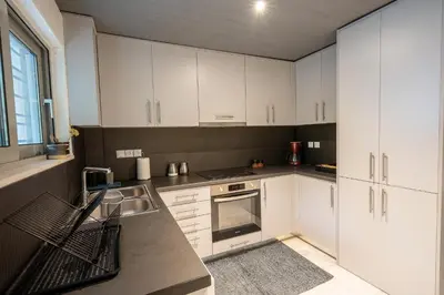 a kitchen with white cabinets and a stove top oven at Athenian Riviera Seafront Residence in Saronida