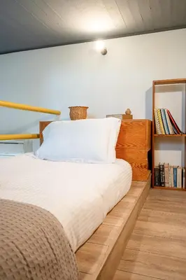 a bedroom with a large white bed and a book shelf at Athenian Riviera Seafront Residence in Saronida
