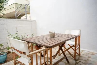 a wooden table and chairs on a patio at Athenian Riviera Seafront Residence in Saronida
