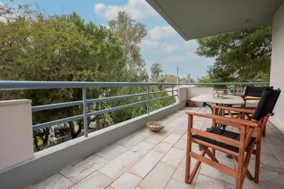 a patio with chairs and a table on a balcony at Athenian Riviera Seafront Residence in Saronida