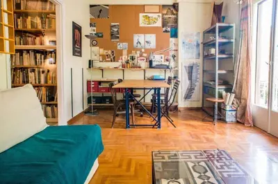 a living room with a table and a desk at Spacious Apartment near Parthenon in Athens