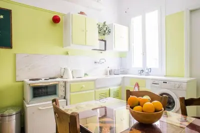 a kitchen with a table with a bowl of oranges on it at Spacious Apartment near Parthenon in Athens