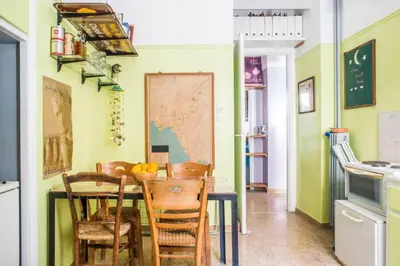 a kitchen with a table with chairs and a map on the wall at Spacious Apartment near Parthenon in Athens