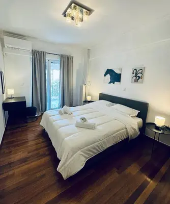a bedroom with a large bed with two towels on it at To Kyma Apartment Athens South in Athens