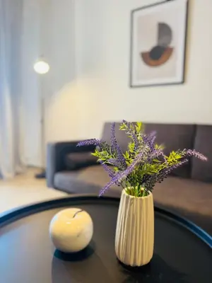 a vase with purple flowers sitting on a table at To Kyma Apartment Athens South in Athens