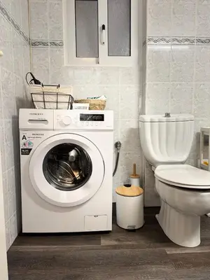 a bathroom with a washing machine and a toilet at To Kyma Apartment Athens South in Athens