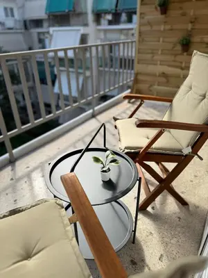 a table and chairs on a balcony with a plant on it at To Kyma Apartment Athens South in Athens