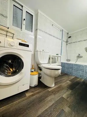 a bathroom with a toilet and a washing machine at To Kyma Apartment Athens South in Athens