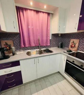 a kitchen with a sink and a pink window at To Kyma Apartment Athens South in Athens