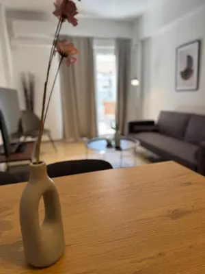 a vase with a flower in it sitting on a table at To Kyma Apartment Athens South in Athens