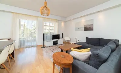 a living room with a blue couch and a table at Spacious Apartment Downtown Glyfada in Athens